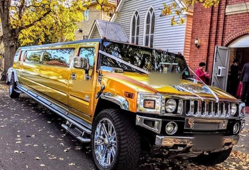 The Golden Sunset gold stretch Hummer limousine dressed with ribbons